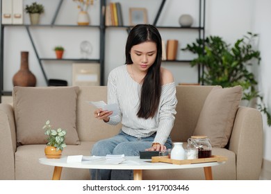 Serious Young Asian Woman Checking Utility Bills Or Receipts, Managing Monthly Expenses