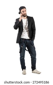 Serious Young Man Talking On The Cellphone Wearing Hat Backwards. Full Body Length Portrait Isolated Over White Background. 