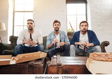 Serious Young Men Watching Football