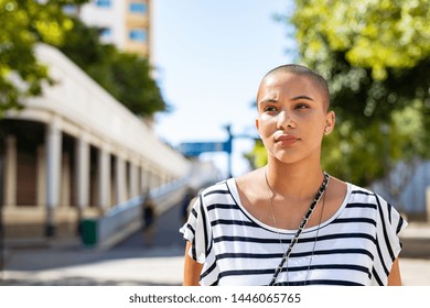 Serious Young Woman With Bald Hair Lost In Deep Thoughts. Stylish Woman In Casual Dress Looking Away Thinking. Proud Young Girl Suffering From Cancer Looking Away While Standing On Road, Copy Space.