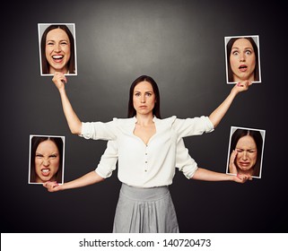serious young woman holding pictures with different mood