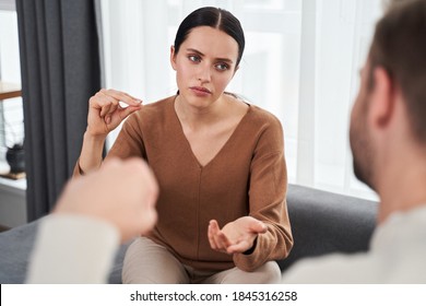 Serious Young Woman Making Sign Language Talk Gesturing With Her Deaf Husband At Home. Deaf Mute Woman Say No To The Man While Using Nonverbal Communication