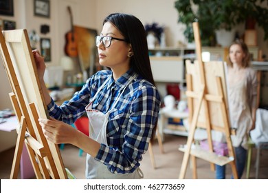 Serious Young Woman Painting At Art Studio