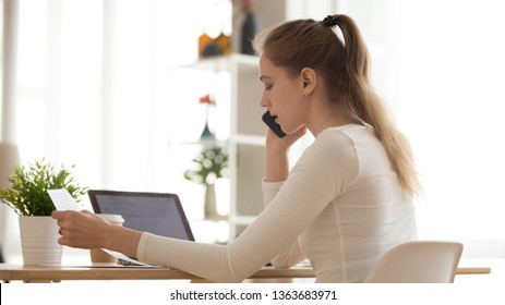 Serious Young Woman Talking On Phone, Discussing, Reading Paper Document, Consulting Client At Workplace, Focused Female Student Look At Notification, Making Call Support Service, Sitting At Desk