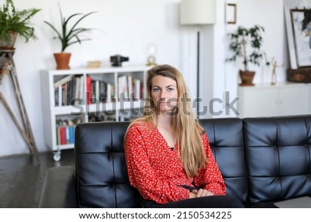 Similar – Entrepreneur woman wearing red shirt working with a laptop sitting on a couch at home