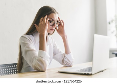Serious young woman thinking hard on task with computer. Concentrated girl in glasses preparing for digital exam on pc. Business woman working in minimal workplace
 - Shutterstock ID 1217664226