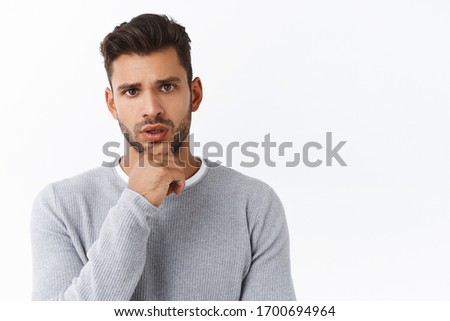 Serious-looking concerned boyfriend listening friend got problem, trying figure out how help, standing white background, touching chin thoughtful, frowning as listening carefully to conversation