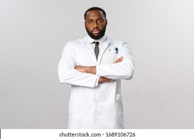 Serious-looking Disappointed African-american Doctor Looking Skeptical And Tired At Person Not Following Covid-19 Quarantine Recommendations, Cross Arms Chest, Staring Camera, Wear White Coat