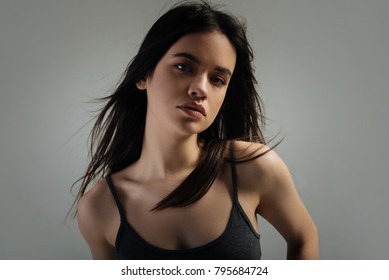 Seriousness. Attractive Humourless Dark-haired Young Woman Thinking And Staring And Wearing A Shirt