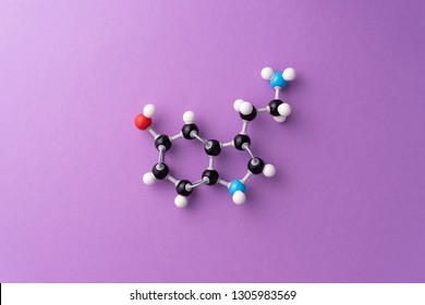 Serotonin chemical formula over purple background - Shutterstock ID 1305983569