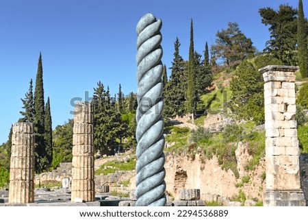 Serpent Column of Plataea or Delphi Tripod in front of the Temple of Apollo in Delphi, Greece, an ancient sanctuary that grew rich as seat of oracle that was consulted on important decisions