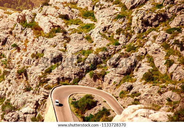 Serpentine\
road to town among rocky mountains in\
Spain.