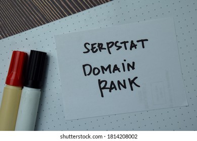 Serpstat Domain Rank write on a paperwork isolated on wooden table.