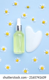 Serum With Floral Extracts For Skincare, Gua Sha Stone For Face Massage. Chamomile Flowers On Yellow Background. Face And Body Care Spa Concept.