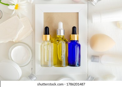 Serum Oil Dropper Glass Bottle Set. Skincare Hair Treatment Cosmetic For Beauty Face. Different Types Of Oil And Serum Mockup On White Background. Top View Flat Lay