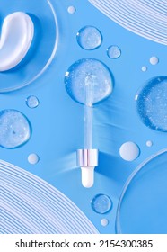 serum pipette smear of cream round transparent drop of transparent gel petri dish on blue background