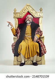 Servants Come hither. Studio shot of a richly garbed king sitting on a throne. - Shutterstock ID 2148701539