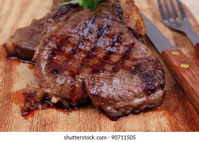 served beef meat barbecue on wooden plate with cutlery