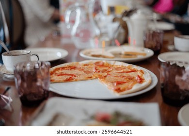 The served dinner table with pizza