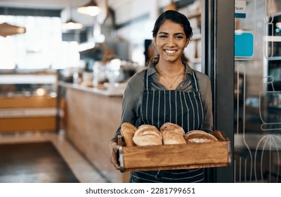 Served fresh just for you. a young woman holding a selection of freshly baked breads in her bakery. - Powered by Shutterstock