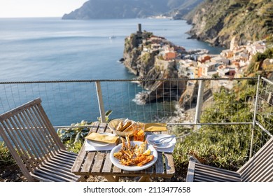 Served lunch table with seafood on coast at Vernazza village in Italy. Concept of mediterranean seafood and summer vacations