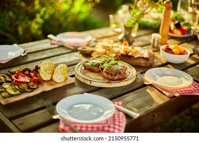 Served with plates dinner table, summer picnic outdoor at home backyard on fresh air, appetizers variety serving on party with grilled vegetables, lemonade, steak, camembert cheese. - Shutterstock ID 2150955771