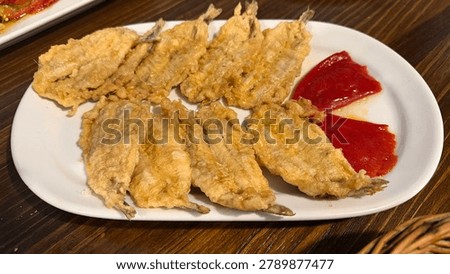 Served Spanish tapas in a Basque restaurant in Madrid - anchovies covered in egg batter and fried - served with roasted red peppers