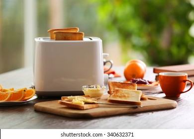 Served Table For Breakfast With Toast, Coffee And Fruit, On Blurred Background