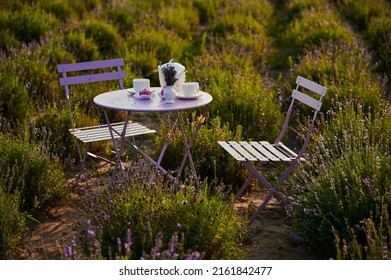 Served Table With Chairs For An Outdoor Tea Party In A Field With Lavender At Sunset