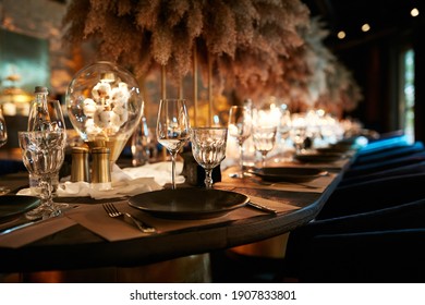 The served table in the luxury restaurant. Dark wooden table, beautiful evening restaurant with luxury rustic decor