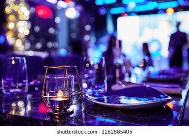 Served table of a night club against the background of multi-colored lights - Powered by Shutterstock