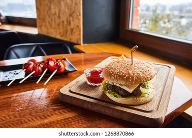 Served table in a rustic cafe with tomatoes and burger