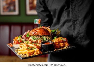 Server in black attire presenting a tray of appetizing food including a burger, loaded fries, and appetizers in a cozy, ambient-lit restaurant - Powered by Shutterstock