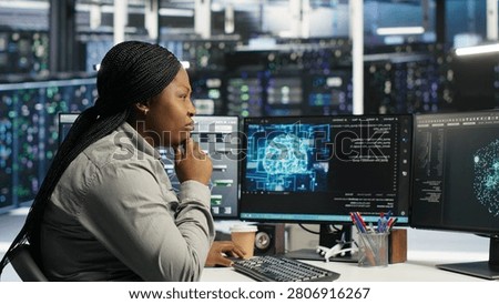 Server facility technical specialist applying AI ML models to set up hardware. African American woman works on AI programming tools in data center, optimizing system.