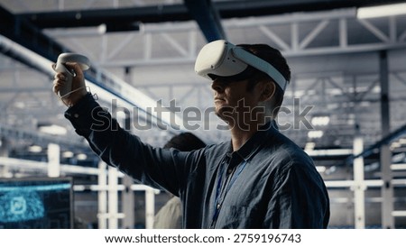 Server farm programmer uses VR headset to install updates and keep AI systems running. Data center employee uses virtual reality tech to write code improving infrastructure output, camera B