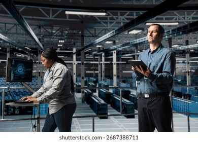 Server farm team of technicians using devices to do infrastructure AI machine learning automatization. Data center programmer and coworker doing maintenance using artificial intelligence