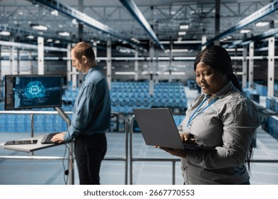 Server farm teamworking admins using laptop to do infrastructure AI machine learning automatization. Data center software developers doing maintenance using artificial intelligence
