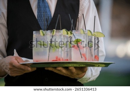 Server Holding Tray of Refreshing Summer Cocktails