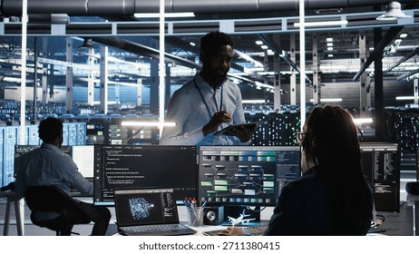 Server hub manager talking with programmer using node tree software to optimize system health. Data center supervisor overseeing IT expert analyzing equipment issues using AI visualization, camera A