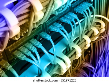 Server rack with blue internet patch cord cables connected to black patch panel in server room horizontal gradient