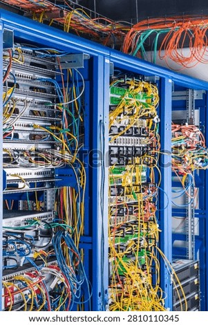 Server rack with fiber optic cables attached to front panel switch ports