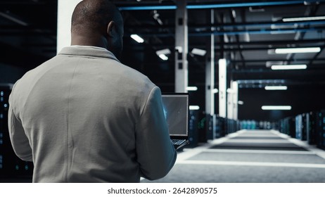 Server room admin using laptop to do infrastructure AI machine learning automatization. Software developer walking in data center doing maintenance using artificial intelligence, camera A