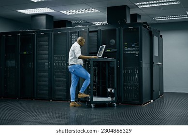 Server room, database and information technology with an engineer man at work on a network mainframe. Computer, programming and cybersecurity with a male technician working in IT support or safety
