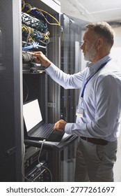 Server room, engineer and connection with laptop for cybersecurity, maintenance or digital storage. Mature person, AI network or machine learning for database system, safety backup or big data center