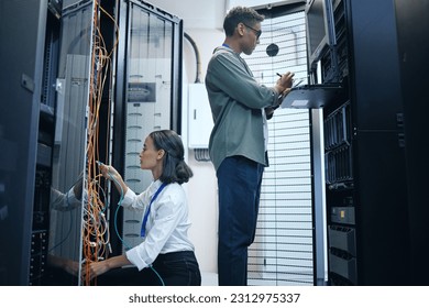 Server room, engineer and IT team with a tablet for programming, cybersecurity or cable maintenance. Man and woman technician together in datacenter for network, software or system upgrade with tech