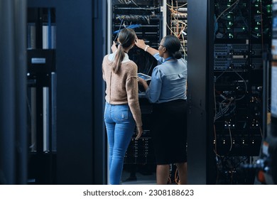 Server room, engineer and women team with tablet for programming, cybersecurity or cable maintenance. Female technicians together in datacenter for network, software or system upgrade with technology - Powered by Shutterstock