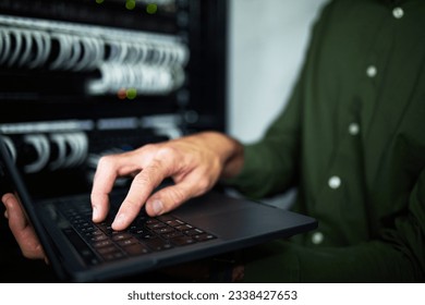 Server room hands, laptop and technician at work for cyber security and building network. Programming, coding and a person or it worker with a computer for a connection system in the workplace - Powered by Shutterstock - Get 15% off with code: PIKWIZARD15