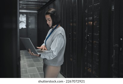 Server room, laptop and technician woman for data center management, system update and cyber security. Focus, serious and inspection of asian electrician, engineering or programmer person typing code - Powered by Shutterstock