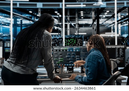 Server room manager overseeing work done by engineer using artificial intelligence to reduce downtime. Team leader supervising employee implementing AI driven solutions for data center equipment