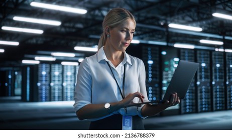 Server Room Specialist Facility with Caucasian Woman System Administrator Working with Data Protection Network. Female Data Center Engineer Using Laptop Computer at the Night Office - Powered by Shutterstock